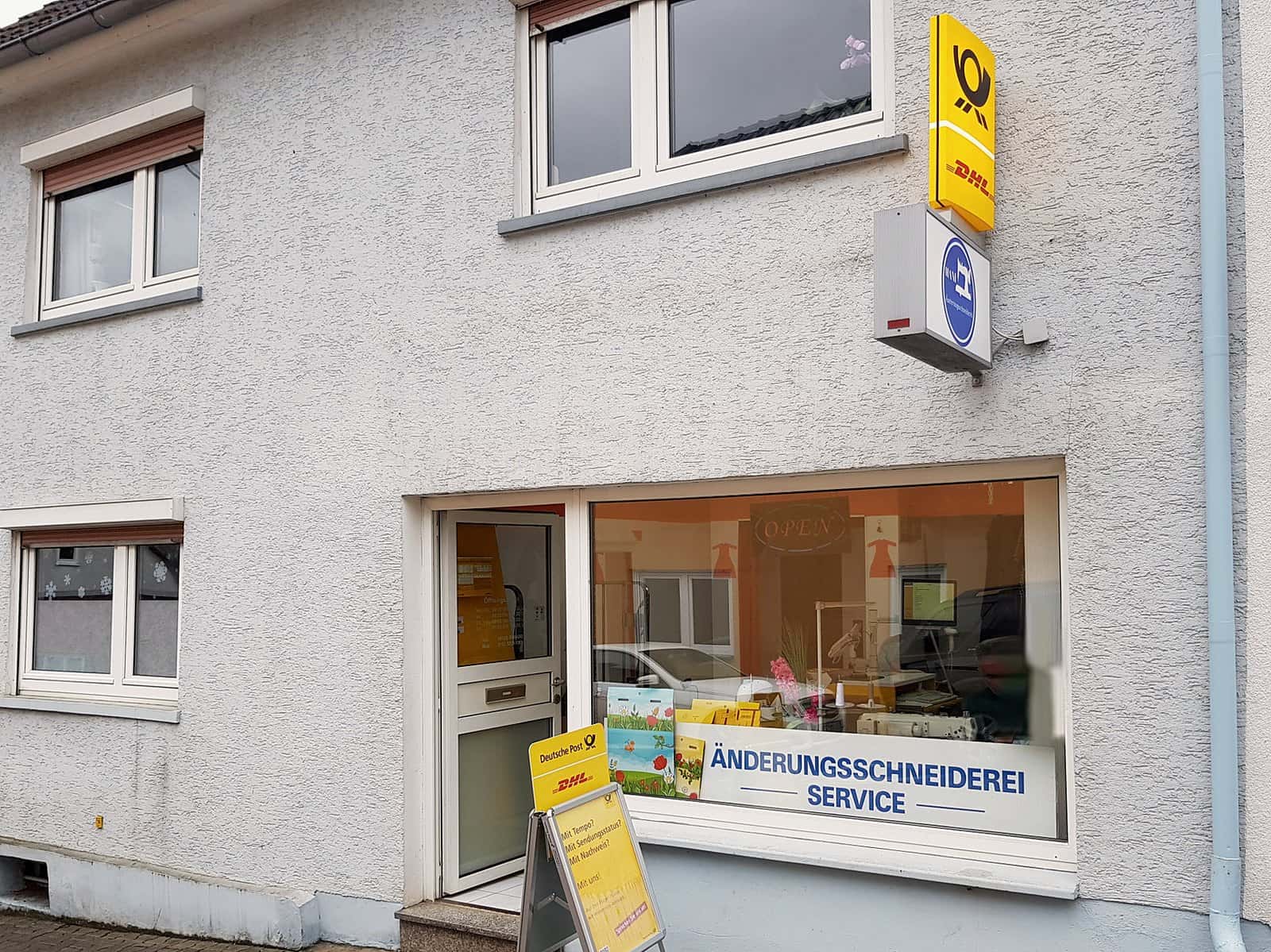 Ladenfront in der Limburger Straße 20 in Taunusstein-Neuhof mit Schaufenster und gelbem Postschild